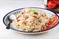 Traditional uzbek pilaf (plov) with tomatoes and red onion