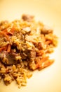 Traditional Uzbekistan pilaf on the rustic background