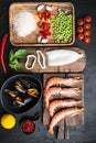 Traditional valenciana paella seafood ingredients with prawns, mussels, rice and spices on black concrete surface, flat lay Royalty Free Stock Photo
