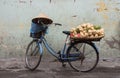 Traditional Vietnamese bicycle load with vegetables and conical hat rested on the handlebar.