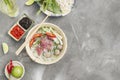 Traditional Vietnamese soup Pho bo with herbs, meat, rice noodles, broth. Pho bo in bowl with chopsticks, spoon. Space for text. Royalty Free Stock Photo