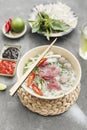 Traditional Vietnamese soup Pho bo with herbs, meat, rice noodles, broth. Pho bo in bowl with chopsticks, spoon. Space for text. Royalty Free Stock Photo