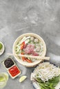Traditional Vietnamese soup Pho bo with herbs, meat, rice noodles, broth. Pho bo in bowl with chopsticks, spoon. Space for text. Royalty Free Stock Photo