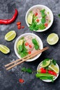 Traditional Vietnamese Soup Pho Bo with Rice Noodles, Beef and Herbs on Dark Background