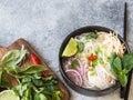 Traditional Vietnamese soup- pho ga in black bowl with chicken and rice noodles, mint and cilantro, green and red onion, chili, Royalty Free Stock Photo