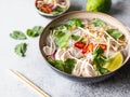 Traditional Vietnamese soup- pho ga in bowl with chicken and rice noodles, mint and cilantro, red onion, chili, bean sprouts and Royalty Free Stock Photo