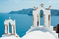 Traditional view of the sea with two white bell towers on the island of Santorini Royalty Free Stock Photo