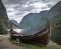 Traditional viking boat near fjord in central Norway with dramatic cloudy sky. Royalty Free Stock Photo