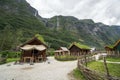 Traditional viking village with dramatic mountains and fjord in the background.