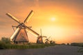 Traditional village with dutch windmills and river at sunset, Holland, Netherlands. Royalty Free Stock Photo