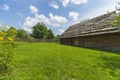 Traditional village house with blue sky, green grass, fence and trees. Ukraine. Royalty Free Stock Photo