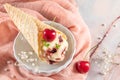 Traditional waffle cones with ice cream and cherry fruits on marble stone surface Royalty Free Stock Photo