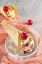 Traditional waffle cones with ice cream and cherry fruits on marble stone surface Royalty Free Stock Photo