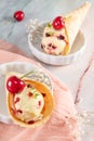 Traditional waffle cones with ice cream and cherry fruits on marble stone surface Royalty Free Stock Photo