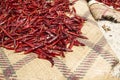 Drying out Red chili peppers in the sun naturally on a grass mat surface.