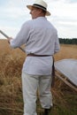 Traditional wheat harvesting ceremony in eastern Poland Lesniowice, village Lublin voivodship in old clothes with scythe in summ