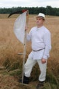 Traditional wheat harvesting ceremony in eastern Poland Lesniowice, village Lublin voivodship in old clothes with scythe in summ