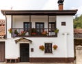 Traditional white house with decorative geranium flowers, typical from Spain. Wooden balcony and windows. Colorful flowers. Royalty Free Stock Photo