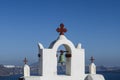 Traditional white and red belfry with cross and bell of Greek orthodox church. Oia, Santorini, Greece Royalty Free Stock Photo