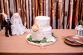 Traditional white wedding cake decorated with fresh flowers. Handmade bride and groom dolls on table Royalty Free Stock Photo