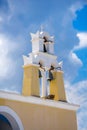 Traditional white-yellow bell tower against cloudy sky at a greek island Royalty Free Stock Photo
