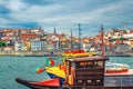 Traditional wine boats in water of Douro River and Ribeira district embankment with colorful buildings