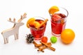 Traditional winter beverage with cinnamon sticks and orange fruit. Glasses with mulled wine or hot drink near wooden