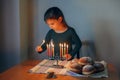 Traditional winter Jewish Hanukkah holiday. Girl lighting candles on menorah for at home. Child celebrating Chanukah festival of Royalty Free Stock Photo