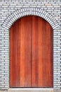 The traditional  wooden arched door and brick wall,which has the Royalty Free Stock Photo