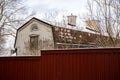 Traditional wooden architecture of Sweden. White wooden house with a brown tiles roof and dark red fence. Royalty Free Stock Photo