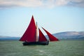 Traditional wooden boat with red sail. Royalty Free Stock Photo