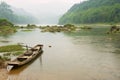 Traditional wooden boat tied at a river bank in rainy weather in Chengyang, Guangxi, China. Royalty Free Stock Photo