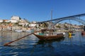 Traditional wooden boats at the Douro river for transporting wine with the bridge Dom Luis Royalty Free Stock Photo
