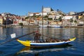 Traditional wooden boats at the Douro river for transporting wine with city on the background of Porto city, Portugal. Royalty Free Stock Photo