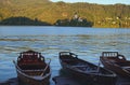 Traditional wooden boats Pletnaon Lake Bled. Ancient Pilgrimage Church of the Assumption of Maria on the small island Royalty Free Stock Photo