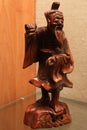 Traditional wooden carved chinese figure of elder man on pedestal