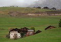 Traditional wooden cottage mountain houses in the green field in the dolomites. Housing in Italian apls. Alpine region