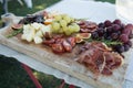 Traditional wooden cutting board with delicious starters to share. On a table Royalty Free Stock Photo