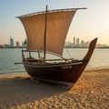 A traditional wooden dhow with a large triangular sail is positioned on a sandy shore Royalty Free Stock Photo