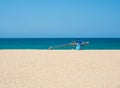 Traditional wooden fishing boat on empty beach against clear blue sky and sea, Kallady Beach, Batticaloa, Sri Lanka Royalty Free Stock Photo