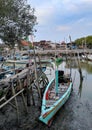 Traditional wooden fishing boats leaning on the harbor at sunset in Surabaya, Indonesia.