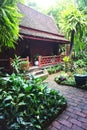 Traditional wooden house with lush jungle garden in rural Thailand Royalty Free Stock Photo