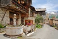 Traditional wooden houses, a traditional fountain and the church in Saint Veran village, with mountain range