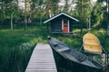 Traditional wooden hut. Finnish sauna on the lake and pier with fishing boats Royalty Free Stock Photo