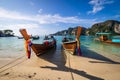 Traditional wooden longtail boats parked at a beach in Phi Phi Island. Clear water and clean beach