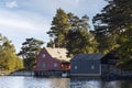 Traditional wooden Norwegian houses surrounded by trees and near the sea Royalty Free Stock Photo