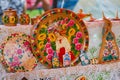 Traditional wooden plates, handmade and handpainted with a girl and bright floral pattern at festival fair