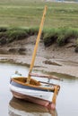 Traditional wooden sailing boat beached on mud