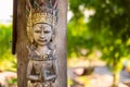 Traditional wooden sculpture of balinese god. Outside asian style interior.