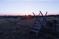 Traditional wooden stile at a fence by sunset